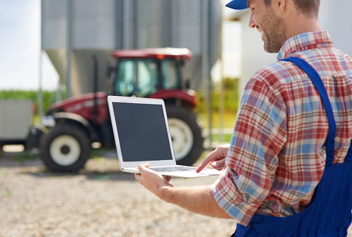 Farmer using laptop on the farm