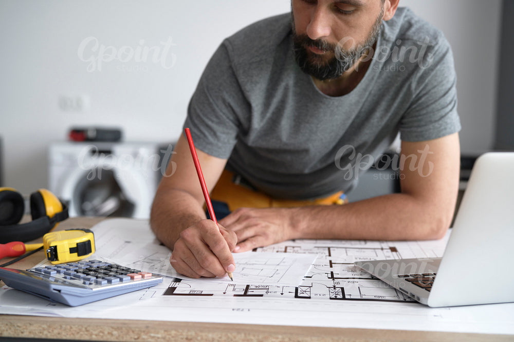 Carpenter writing down measurements on his projects