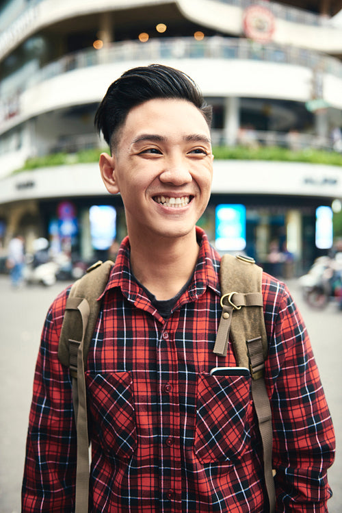 Young Asian man smiling and looking away
