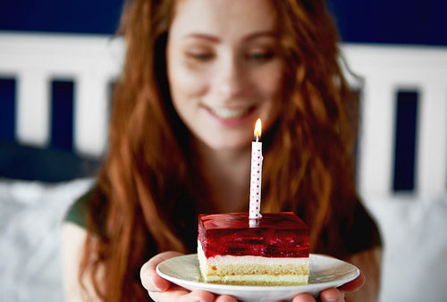 Close up of woman with a piece of birthday cake