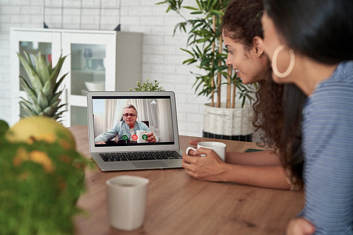 Two women during video call with father