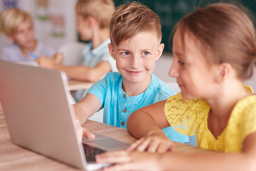 Girl and boy using the computer in the classroom
