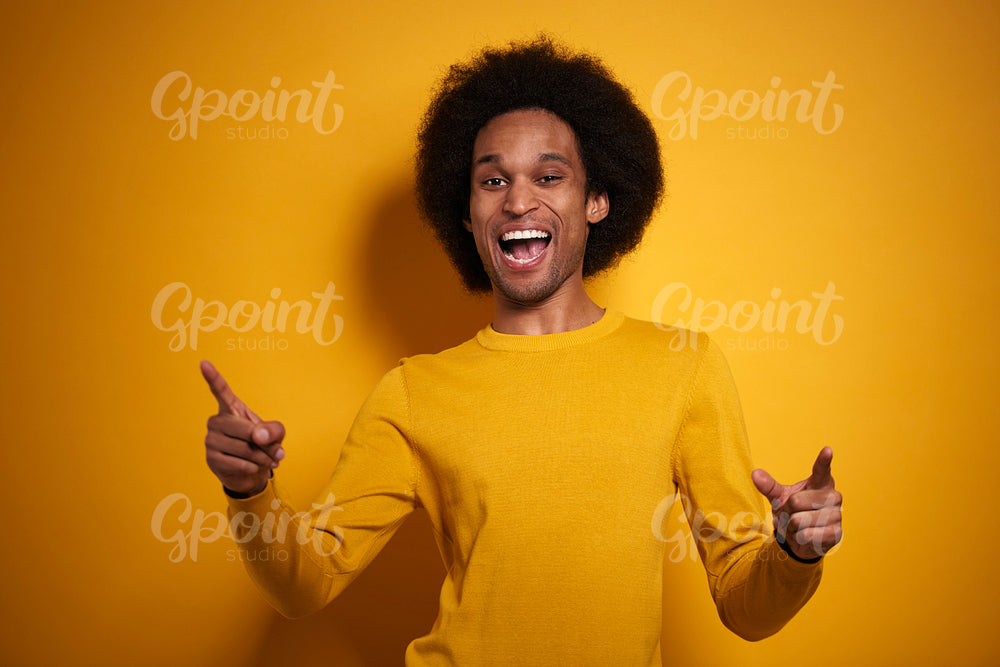 Happy African man on yellow background