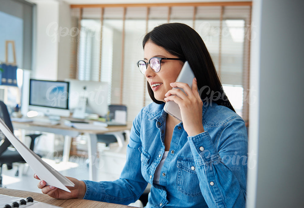 Asian woman in the office talking on the phone