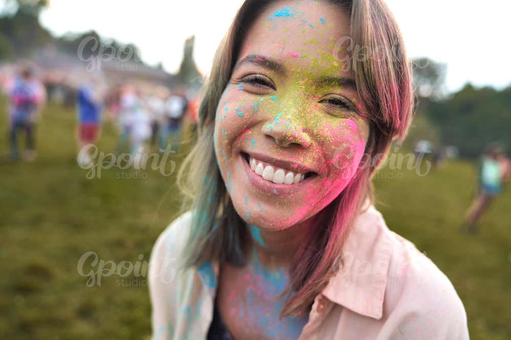 Smiling caucasian woman enjoying the colour powder festival 