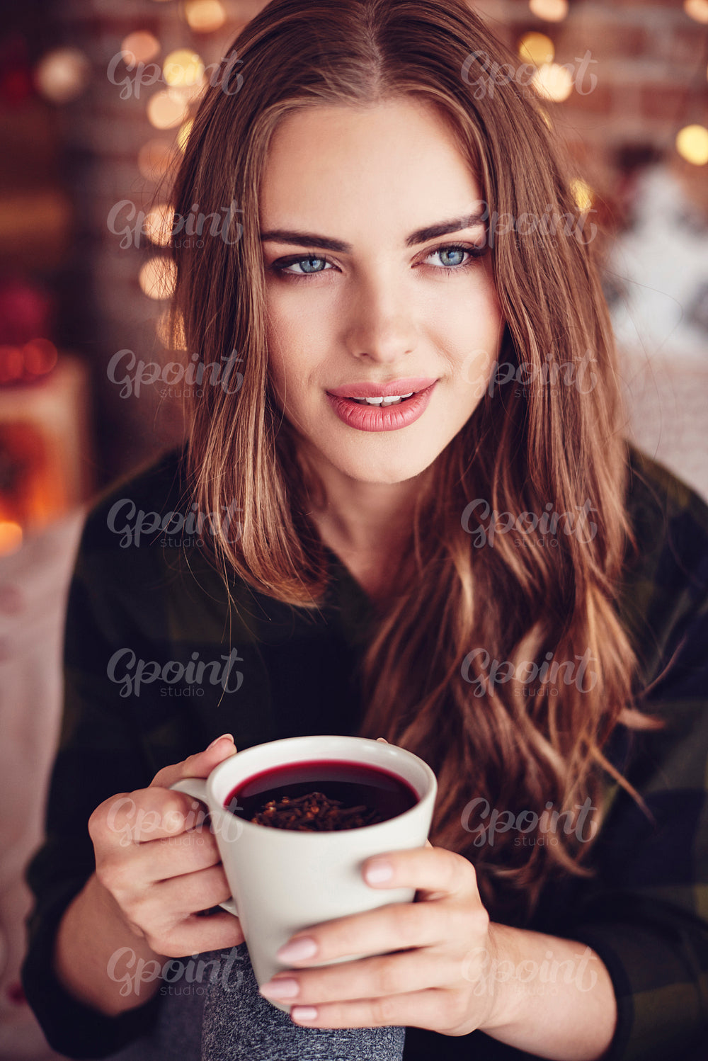 Beautiful woman holding a mug of mulled wine with ginger