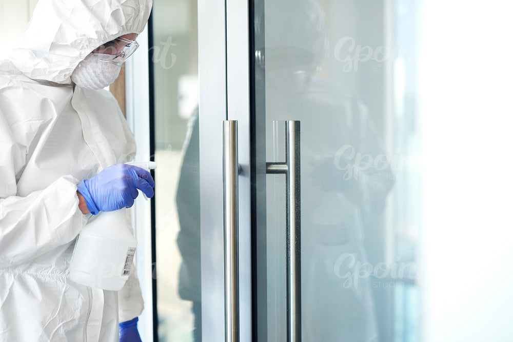Technicians disinfecting a door handle