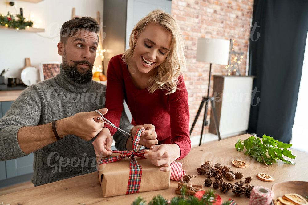 Happy couple packing a Christmas present together