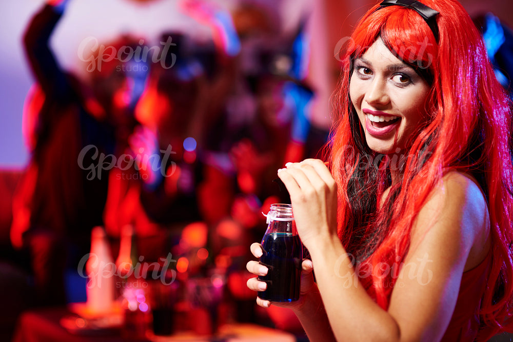 Woman in scary dressing drinking a drink