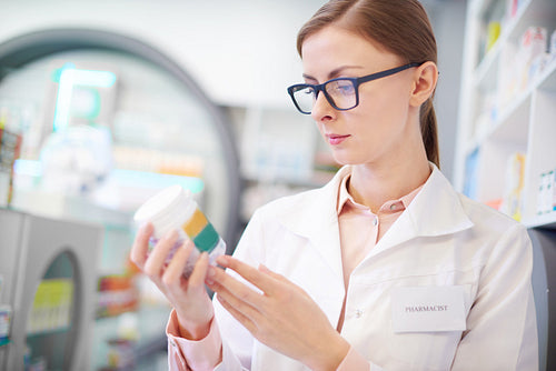 Pharmacist reviewing medicine label on bottle