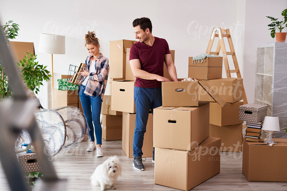 Young couple packing their stuff into boxes