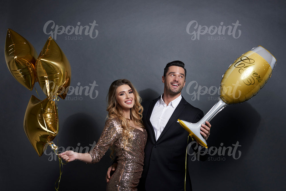 Happy couple with balloons celebrating at studio shot
