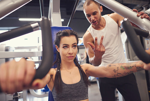 Personal trainer with woman in fitness center