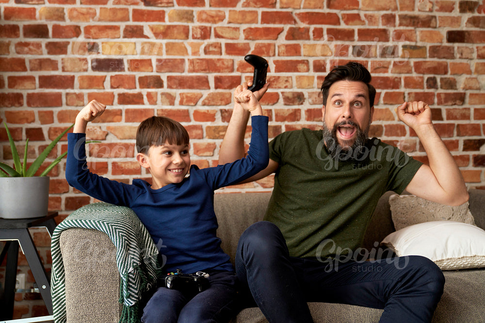 Father and son have fun while playing video game