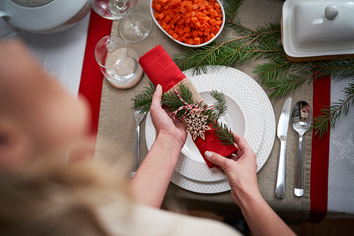 Woman putting napkin on Christmas table