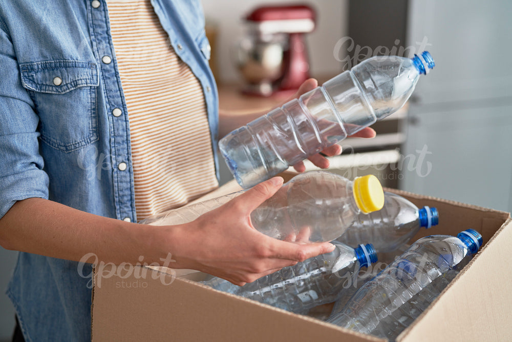 Woman preparing plastic bottles for recycling