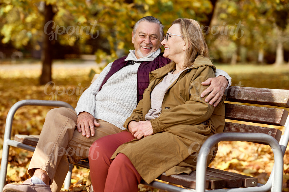 Senior caucasian couple sitting at the bench in park   