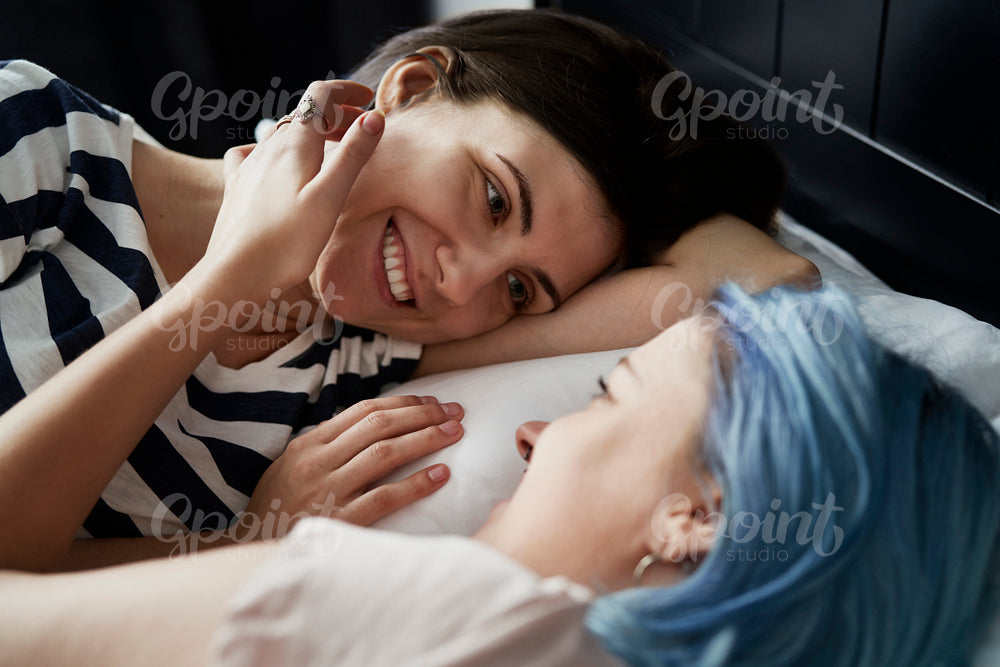 Close up of happy lesbian couple lying on bed