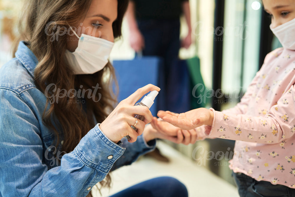 Close up of mom sanitizing her daughter's hands