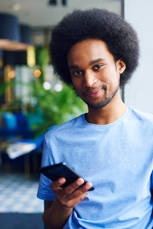 Portrait of young African man using mobile phone