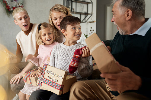 Multi generation caucasian family opening Christmas presents and having fun