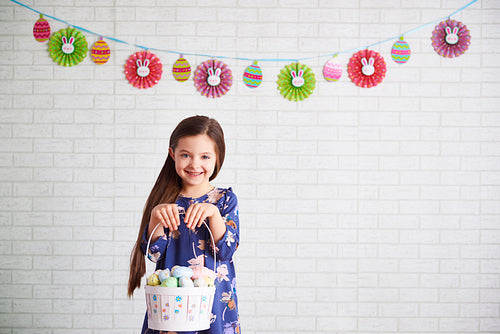 Smiling child holding a basket of easter eggs