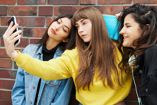 Three girls making a selfie by mobile phone
