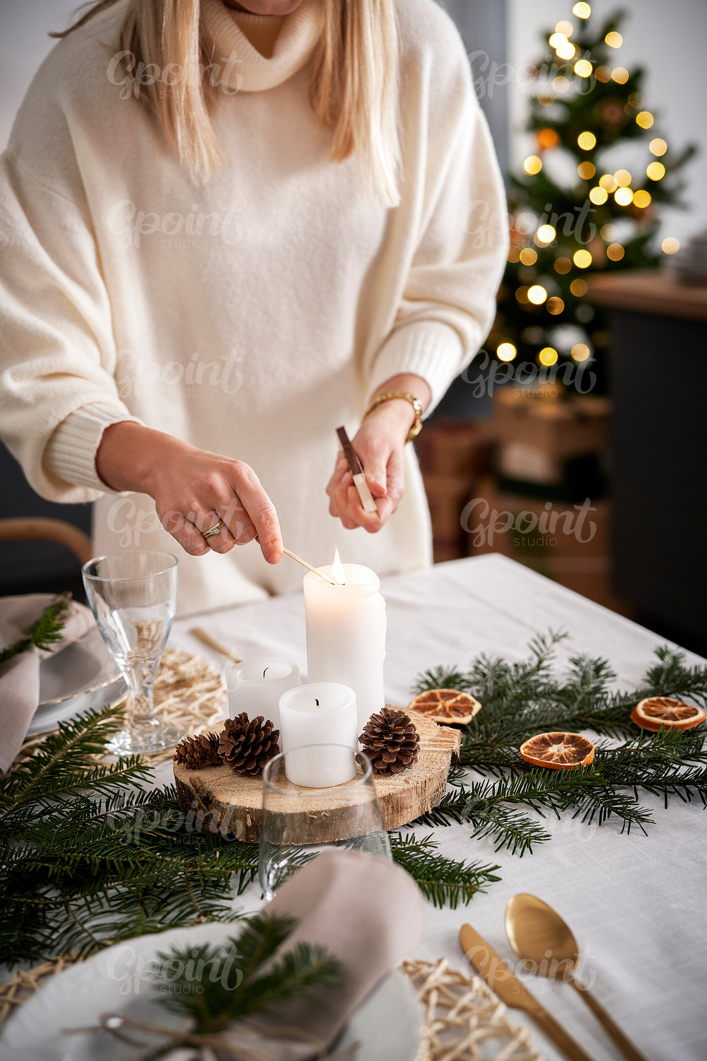 Close up woman lights a candle in Christmas Eve