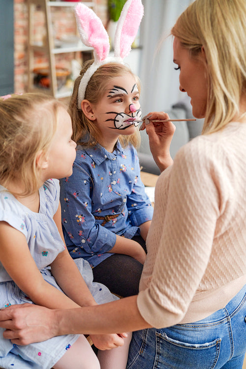 Mom painting an Easter bunny on her daughter's face