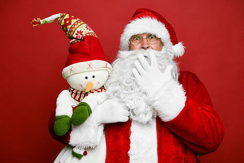 Funny caucasian Santa Claus with cute snowman