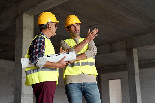 Two caucasian engineers discussing on construction site