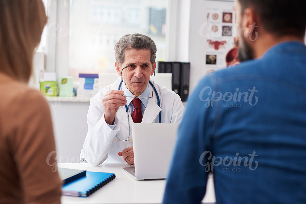 Couple talking with doctor in doctor's office