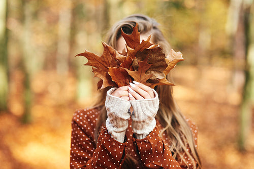 Young woman with autumnal leafs