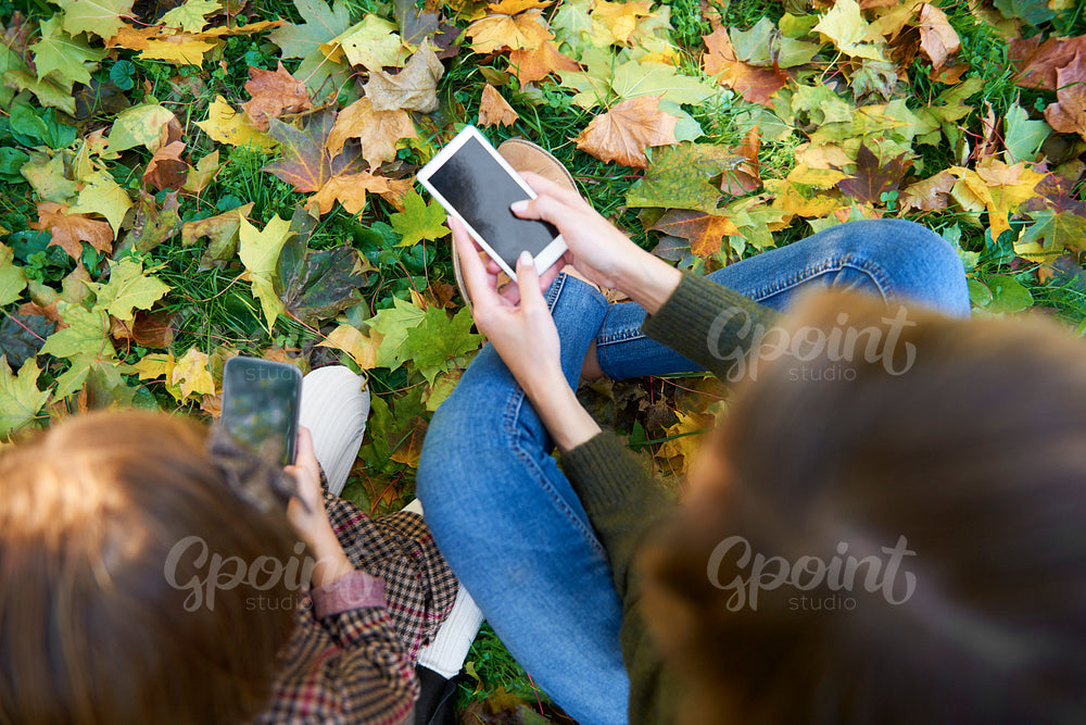 High angle view of mother and daughter with mobile phone