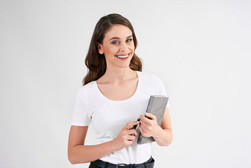 Smiling woman holding a book in studio shot