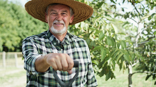 Handheld video portrait of happy farmer in a straw hat