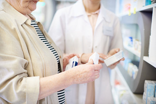 Pharmacist advising senior woman on medicine