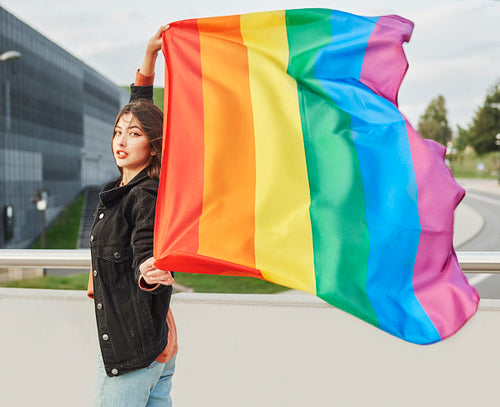 Portrait of young woman with rainbow flag