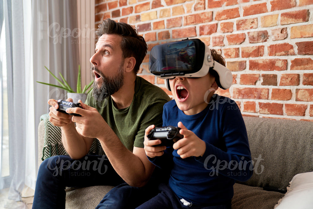 Excited father and son during playing video game at home