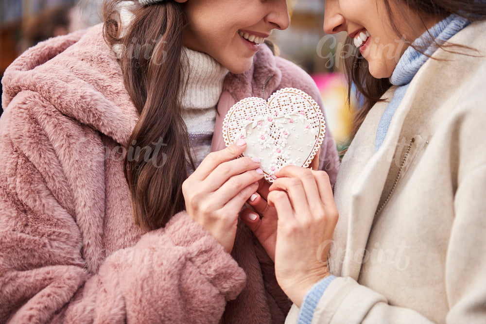 Women connected with a heart shape gingerbread cookie