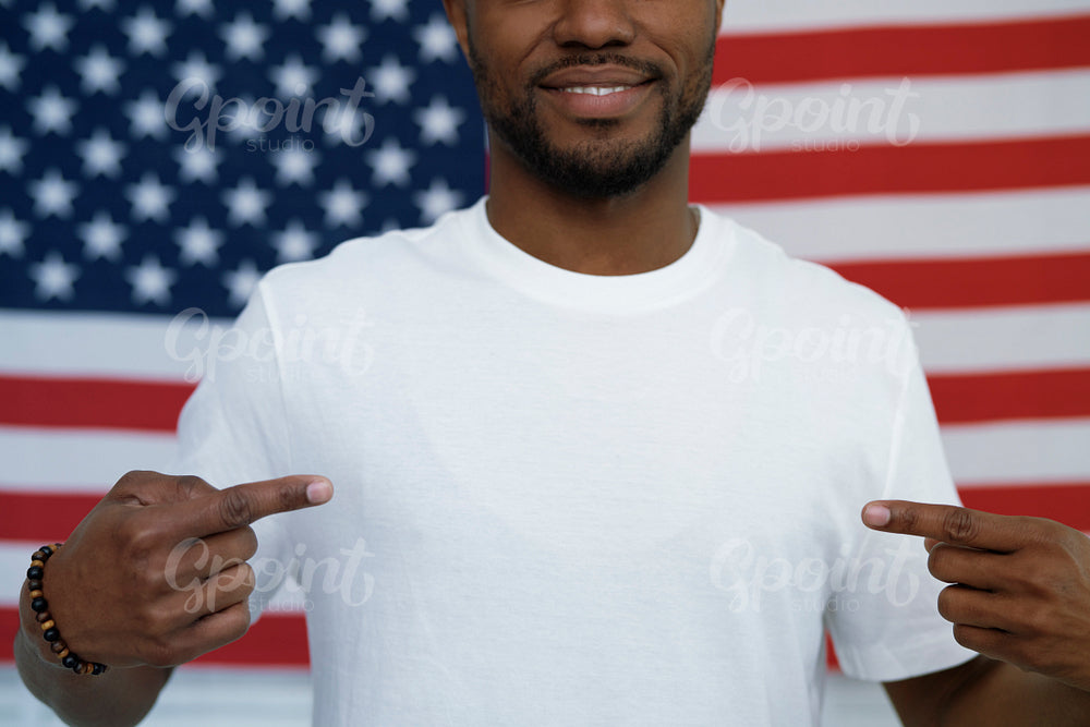 Cheerful black man pointing on copy space on t-shirt