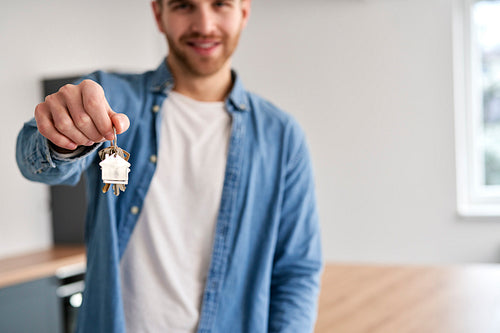 Young caucasian man holding  a bunch of keys for new flat