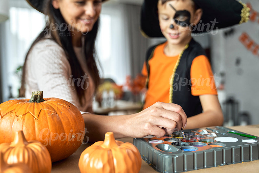 Mom preparing her son for Halloween party  