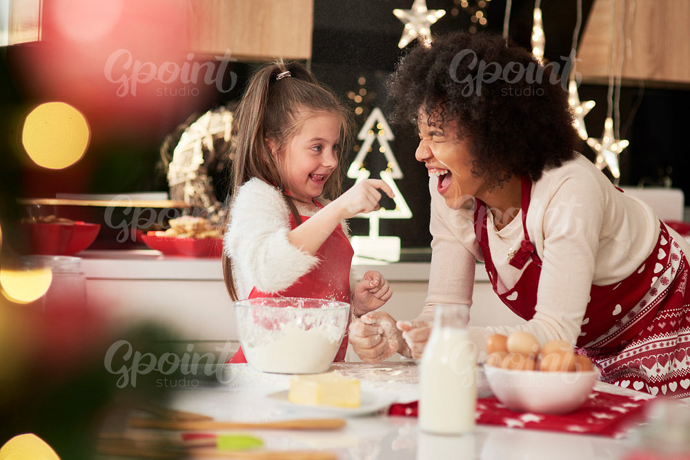 Mother and daughter enjoying in the kitchen at Christmas