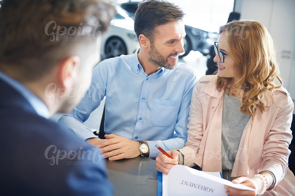 Front view of couple in the car dealership