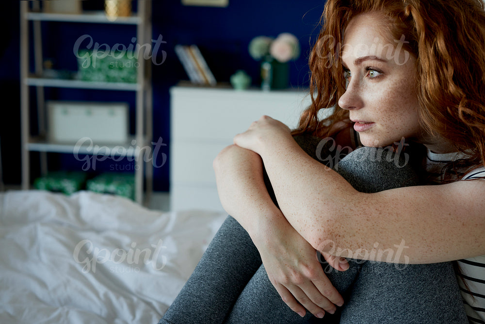 Redhead thoughtful woman in her bed