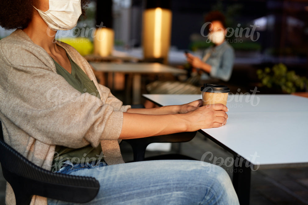 Woman in face mask drinking take away coffee