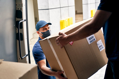 Close up of couriers unloading packages from a delivery truck