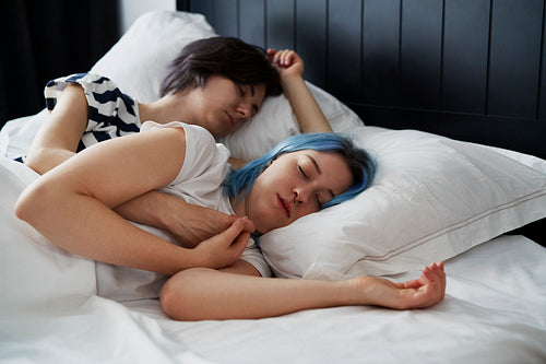 Lesbian couple sleeping cuddled together