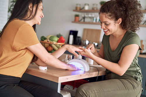 Two women making nail beauty treatments at home